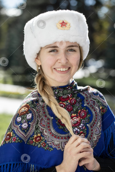 Скачать Портрет красивой молодой славянской девушки в белой меховой шапке-ушанке. фотосток Ozero