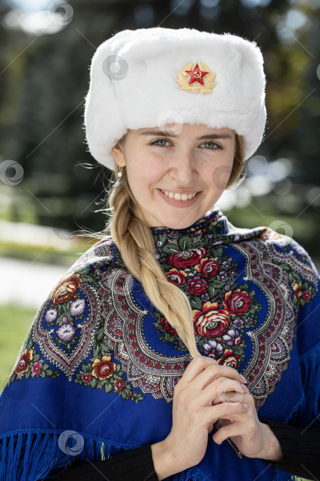 Скачать Портрет красивой молодой славянской девушки в белой меховой шапке-ушанке. фотосток Ozero