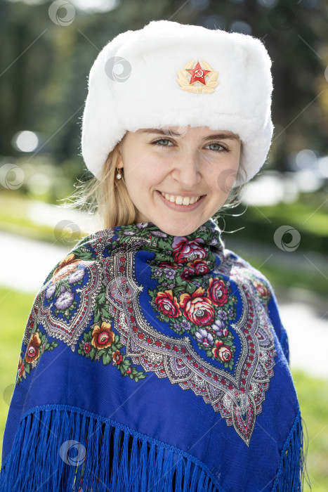 Скачать Портрет красивой молодой славянской девушки в белой меховой шапке-ушанке. фотосток Ozero