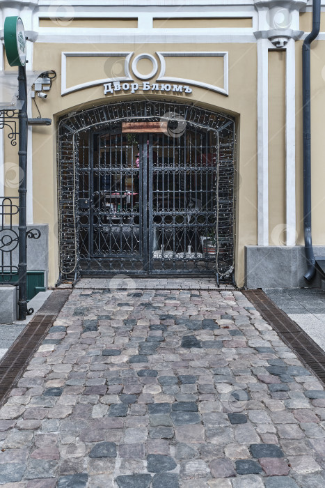 Скачать Вход в исторический внутренний двор Blum House с коваными воротами и мощеной дорожкой фотосток Ozero