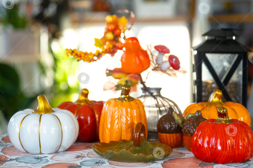Скачать Декор белой классической кухни с тыквами, гирляндами, осенним букетом из желтых листьев к Хэллоуину и сбору урожая. Осеннее настроение в домашнем интерьере, современный стиль лофт. недвижимость, страхование, ипотека фотосток Ozero
