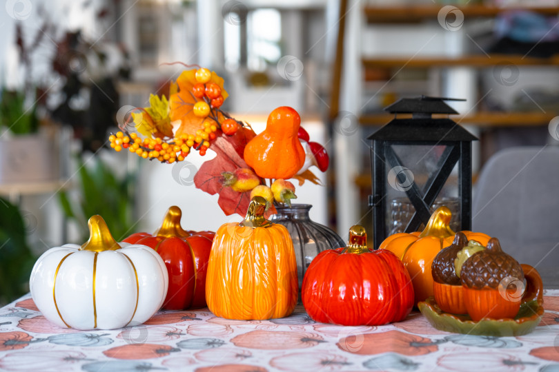 Скачать Декор белой классической кухни с тыквами, гирляндами, осенним букетом из желтых листьев к Хэллоуину и сбору урожая. Осеннее настроение в домашнем интерьере, современный стиль лофт. недвижимость, страхование, ипотека фотосток Ozero