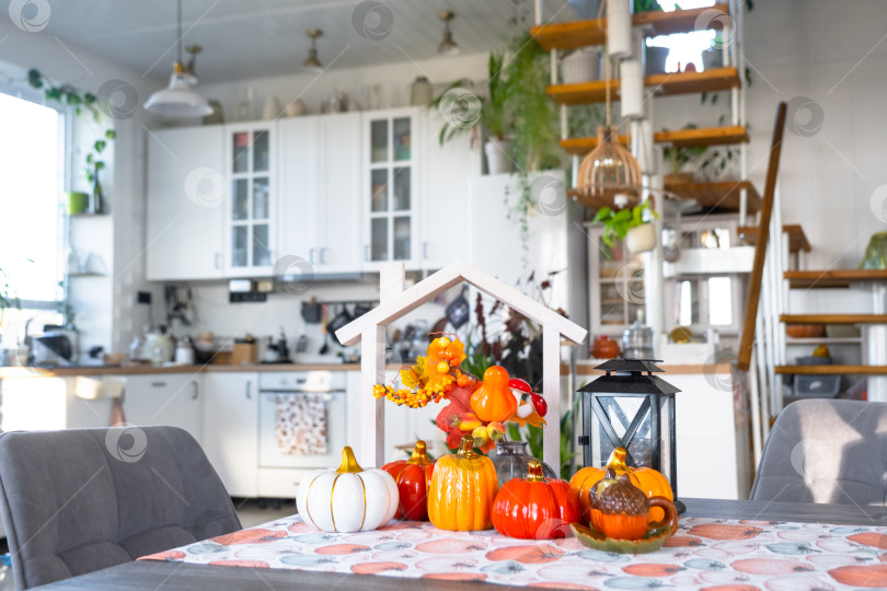 Скачать Уютный осенний декор на белой кухне с крошечным домиком и ключами, тыквами, осенними листьями, осенним настроением, Хэллоуином, праздником урожая, жильем, переездом, ипотекой, страховкой. фотосток Ozero