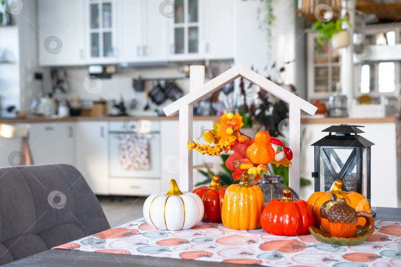 Скачать Уютный осенний декор на белой кухне с крошечным домиком и ключами, тыквами, осенними листьями, осенним настроением, Хэллоуином, праздником урожая, жильем, переездом, ипотекой, страховкой. фотосток Ozero