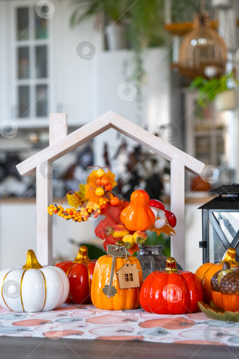 Скачать Уютный осенний декор на белой кухне с крошечным домиком и ключами, тыквами, осенними листьями, осенним настроением, Хэллоуином, праздником урожая, жильем, переездом, ипотекой, страховкой. фотосток Ozero
