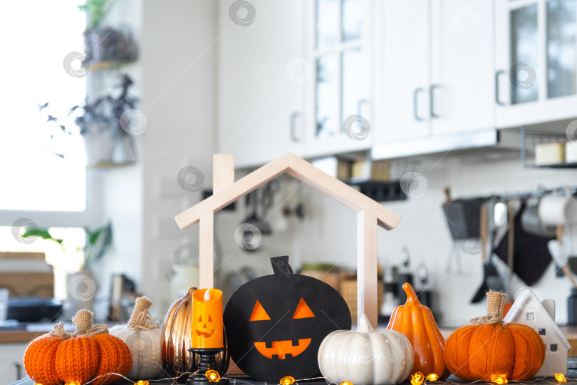 Скачать Декор белой классической кухни с тыквами, гирляндами, Джеком латерном для Хэллоуина и сбора урожая в tiny home. Осеннее настроение в домашнем интерьере, современный стиль лофт. недвижимость, страхование, ипотека фотосток Ozero