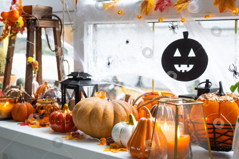 Скачать Праздничный декор дома на подоконнике к Хэллоуину - тыквы, фонарики-домкраты, черепа, паутина, пауки, скелеты, свечи и гирлянда - уютное и жуткое настроение фотосток Ozero