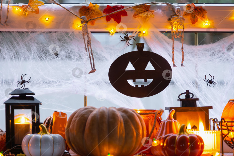Скачать Праздничный декор дома на подоконнике к Хэллоуину - тыквы, фонарики-домкраты, черепа, паутина, пауки, скелеты, свечи и гирлянда - уютное и жуткое настроение фотосток Ozero