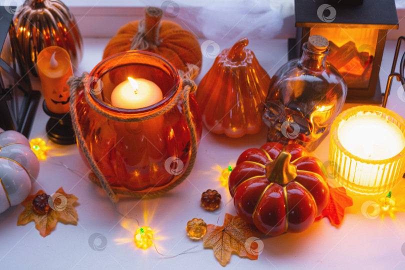 Скачать Праздничный декор дома на подоконнике к Хэллоуину - тыквы, фонарики-домкраты, черепа, паутина, пауки, скелеты, свечи и гирлянда - уютное и жуткое настроение фотосток Ozero