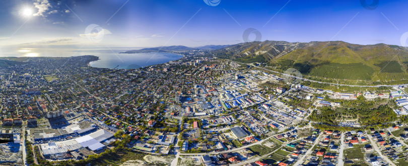 Скачать Панорама города Геленджика. На переднем плане жилые кварталы. Справа - Кавказские горы. На заднем плане - Геленджикская бухта. Солнечная погода фотосток Ozero