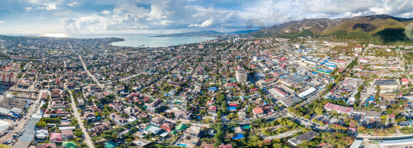 Скачать Панорама города Геленджика. На переднем плане жилые кварталы. Справа - Кавказские горы. На заднем плане - Геленджикская бухта. Солнечная погода фотосток Ozero