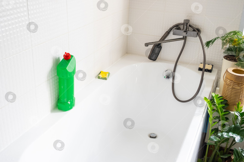 Скачать Крупным планом бутылка с моющим средством в ванной комнате дома, губка для мытья посуды и резиновые перчатки в ванной. Наведение порядка, чистоты и гигиены в доме, услуги по уборке фотосток Ozero