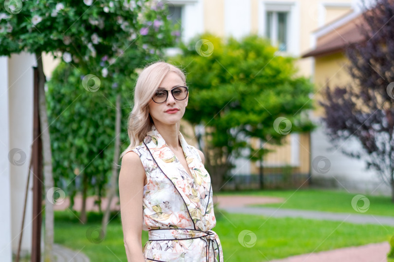 Скачать Женщина в цветастом платье стоит перед желтым домом фотосток Ozero