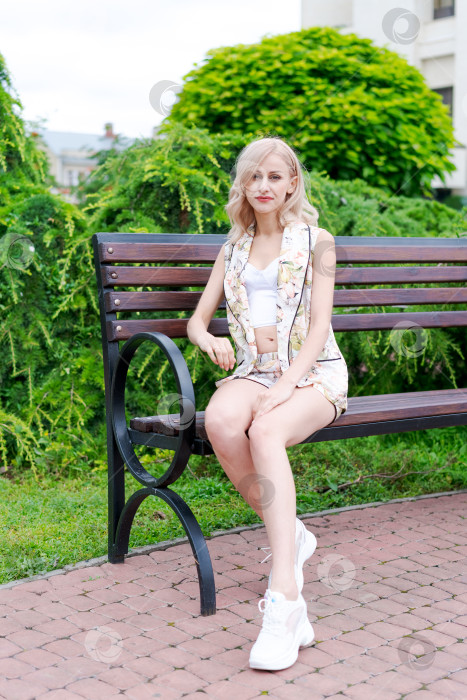 Скачать Женщина сидит на скамейке в парке фотосток Ozero