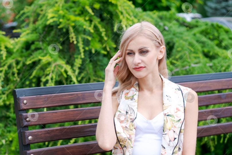 Скачать Блондинка сидит на скамейке фотосток Ozero