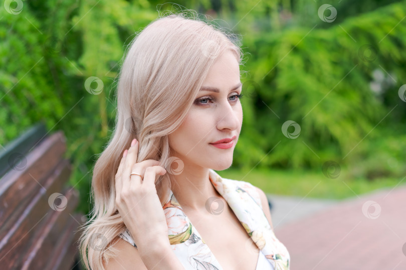 Скачать Блондинка с длинными волосами сидит на скамейке фотосток Ozero