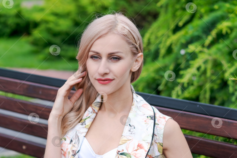 Скачать Блондинка сидит на скамейке фотосток Ozero