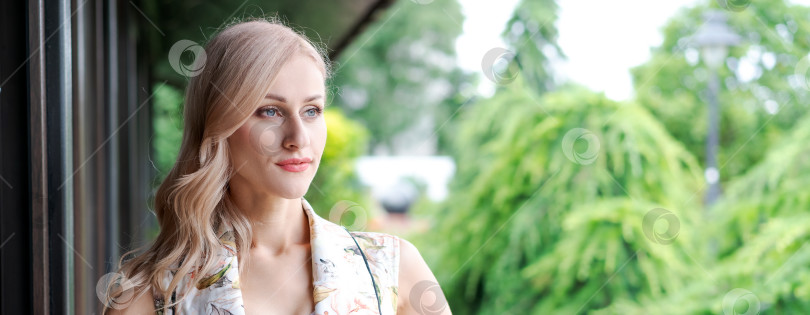 Скачать Женщина со светлыми волосами и в белом платье стоит перед окном фотосток Ozero