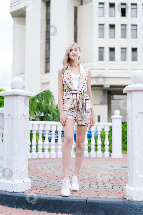 Скачать Женщина стоит перед зданием в белой рубашке и шортах фотосток Ozero