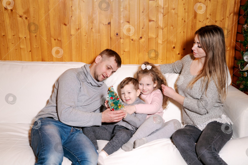 Скачать Мужчина и двое детей сидят на диване фотосток Ozero