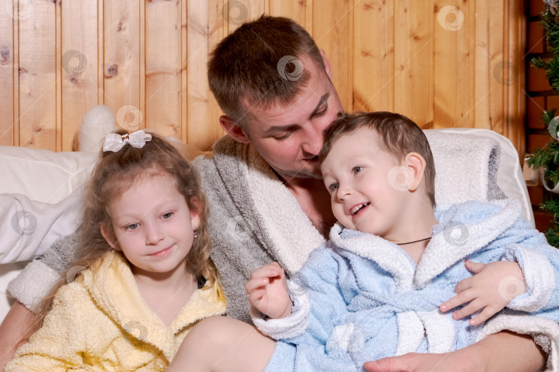 Скачать Мужчина обнимает двух детей в пижамах фотосток Ozero