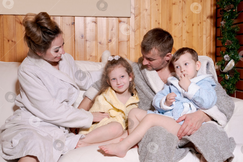 Скачать Семья из четырех человек сидит на кровати фотосток Ozero
