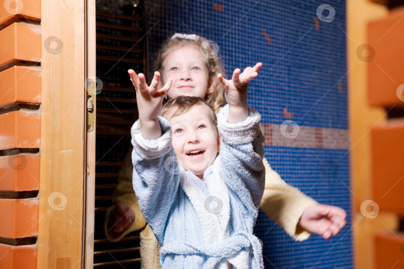 Скачать Мальчик и девочка стоят перед кирпичной стеной фотосток Ozero