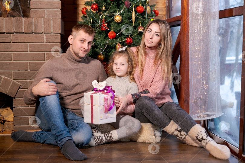 Скачать Мужчина и женщина сидят на полу с ребенком фотосток Ozero