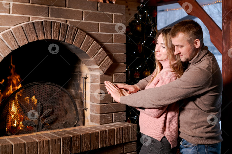 Скачать Мужчина и женщина стоят перед камином фотосток Ozero