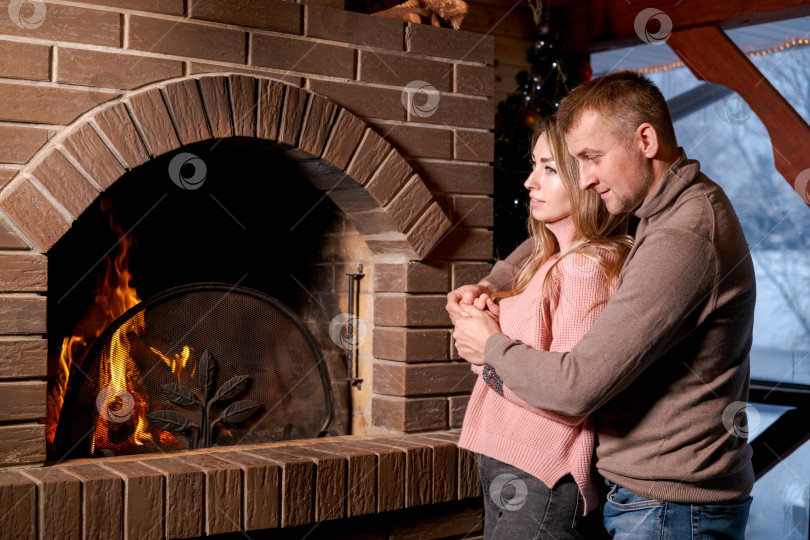 Скачать Мужчина и женщина стоят перед камином фотосток Ozero