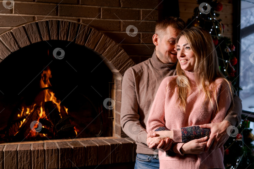 Скачать Мужчина и женщина стоят перед камином фотосток Ozero