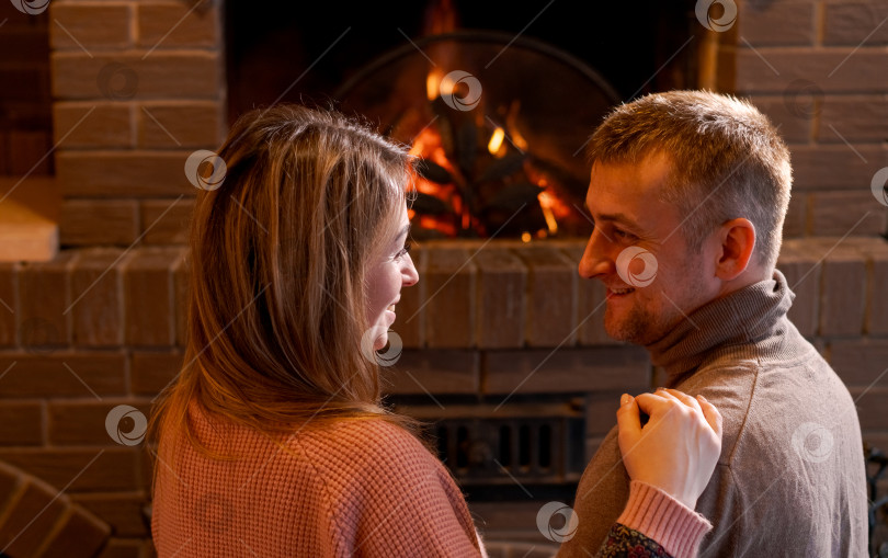 Скачать Мужчина и женщина стоят перед камином фотосток Ozero