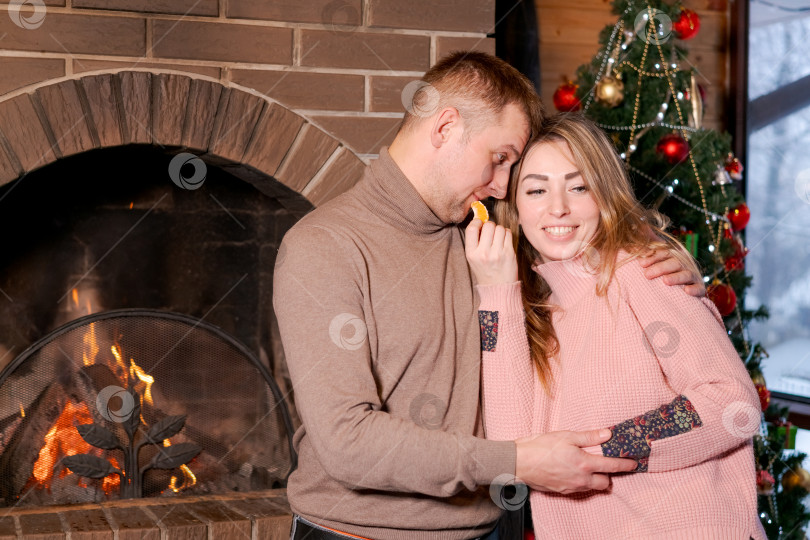 Скачать Мужчина и женщина обнимаются перед камином фотосток Ozero