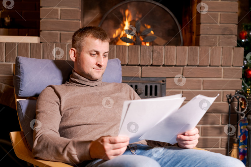 Скачать Мужчина сидит в кресле и читает газеты фотосток Ozero