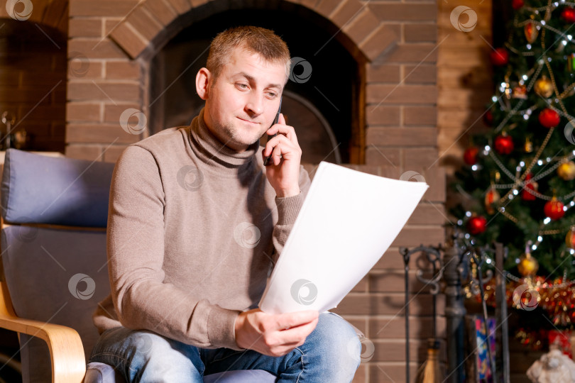 Скачать Мужчина сидит в кресле и разговаривает по мобильному телефону фотосток Ozero