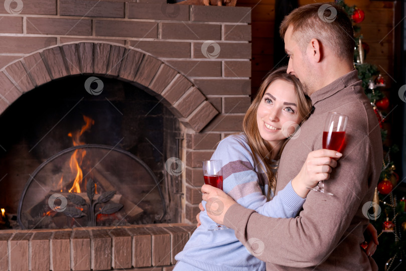 Скачать Мужчина и женщина обнимаются и держат в руках бокалы с вином фотосток Ozero