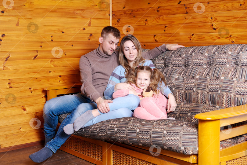 Скачать Мужчина и женщина сидят на диване с ребенком фотосток Ozero