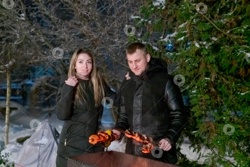 Скачать Мужчина и женщина стоят рядом с грилем фотосток Ozero