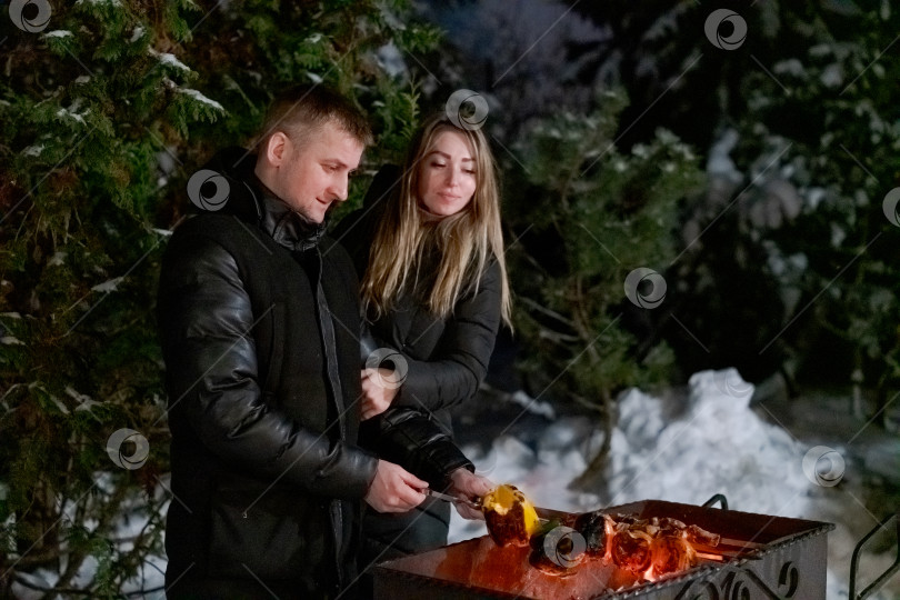 Скачать Мужчина и женщина стоят рядом с грилем фотосток Ozero