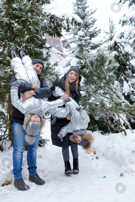 Скачать Семья из четырех человек позирует для фотосессии на снегу фотосток Ozero