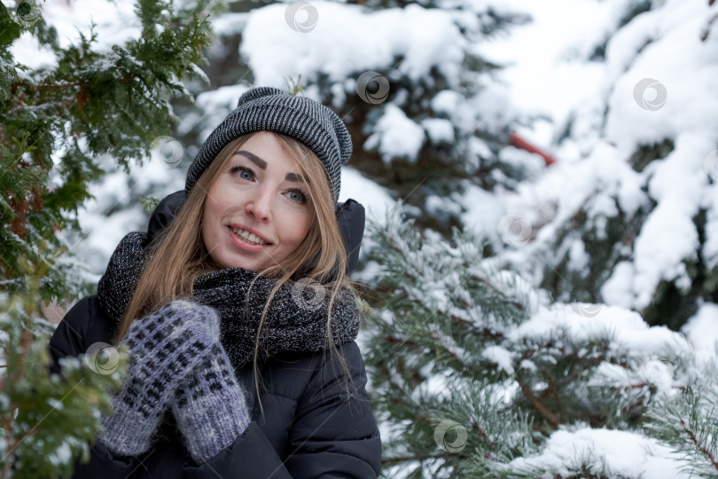 Скачать Женщина в черном пальто и шляпе стоит на снегу фотосток Ozero