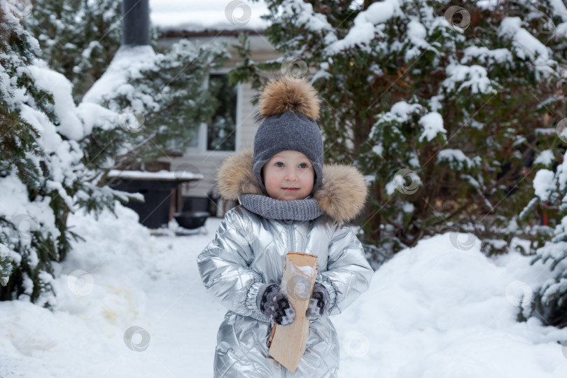 Скачать Маленькая девочка в серебристом пальто и шляпке держит в руках сумку фотосток Ozero