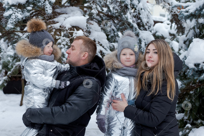 Скачать Семья из четырех человек позирует для фотосессии на снегу фотосток Ozero