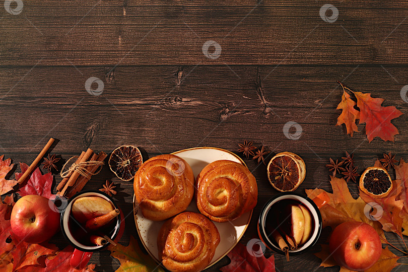 Скачать Булочки с корицей и горячим осенним напитком, глинтвейн с яблоками и осенними опавшими листьями, бадьян, имбирь и корица на деревянном столе, баннер для демонстрации, концепция осеннего поздравления, макет меню. фотосток Ozero