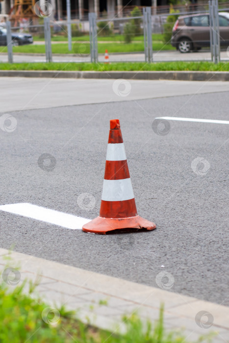 Скачать На обочине дороги виден красно-белый дорожный конус фотосток Ozero