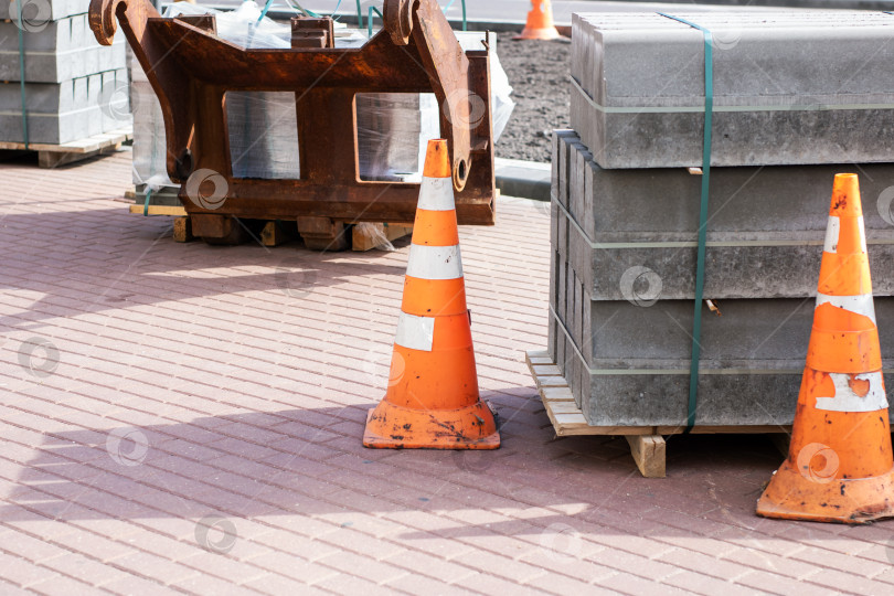 Скачать Дорожные конусы и уложенные друг на друга бетонные плиты на кирпичном покрытии - Строительная площадка фотосток Ozero