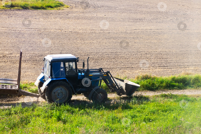 Скачать Синий трактор сегодня активно работает на сельскохозяйственном поле фотосток Ozero