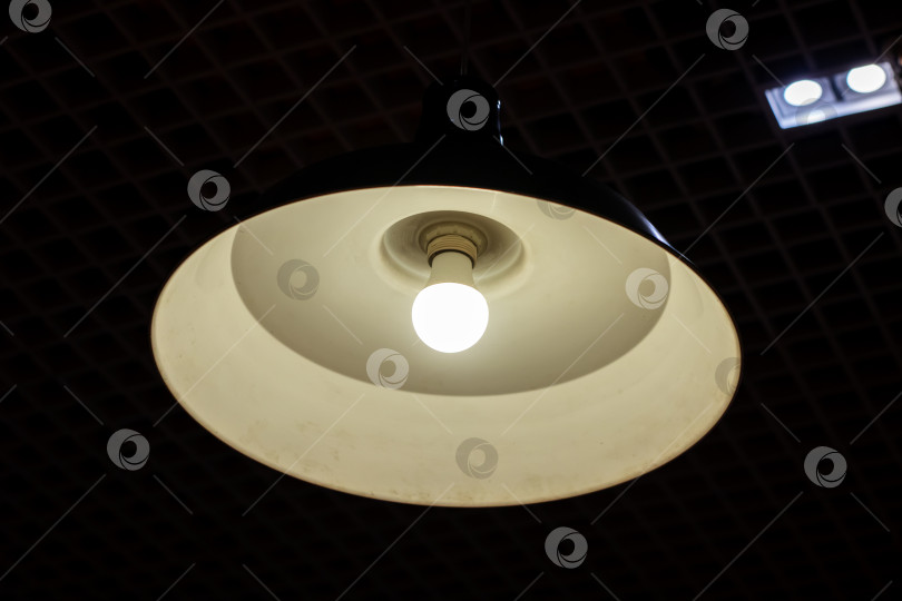 Скачать В тускло освещенной комнате к потолку подвешена единственная лампочка фотосток Ozero