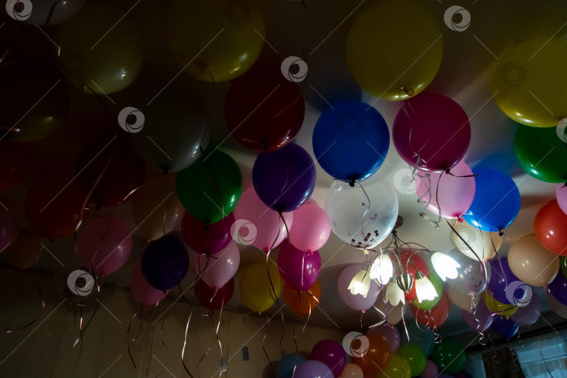 Скачать Потолок, украшенный разноцветными воздушными шарами для вечеринок и свисающими гирляндами фотосток Ozero
