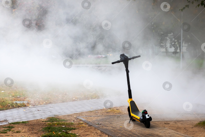 Скачать Черно-желтый скутер окутан густым облаком дыма фотосток Ozero